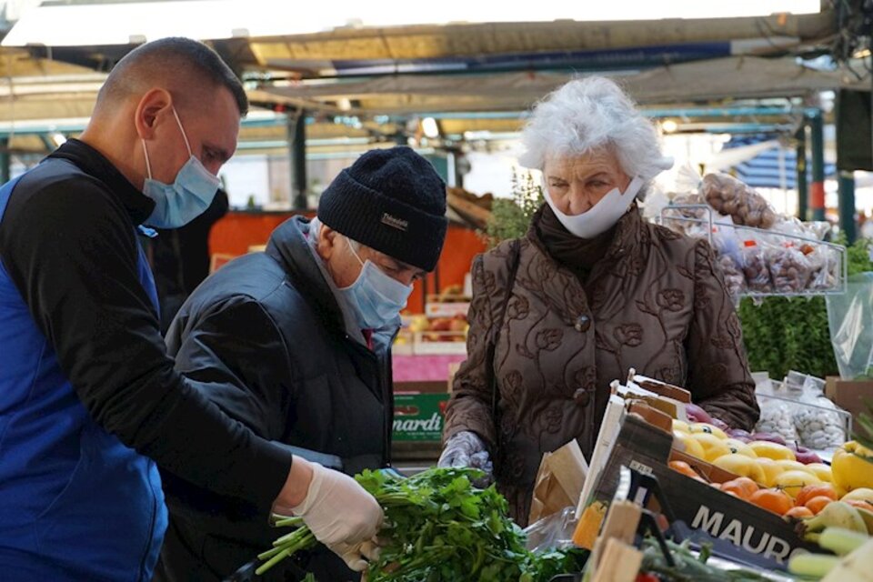 Gente con barbijos en un mercado de frutas en Venecia.  (Fuente: EFE)