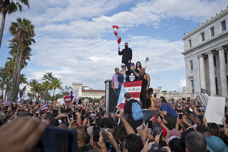 El rapero René Pérez se dirige a la multitud reunida ayer en San Juan para exigir la renuncia de Roselló. (Fuente: AFP)