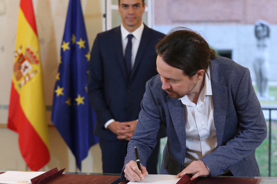 Iglesias, con Sánchez detrás, firma la ley de presupuesto para el 2019 en octubre del año pasado.  (Fuente: EFE)