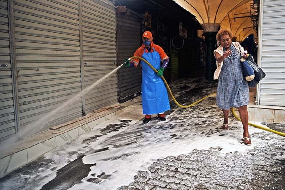 Un trabajador municipal desinfecta un mercado en la favela de Rocinha, en Río de Janeiro.  (Fuente: AFP)