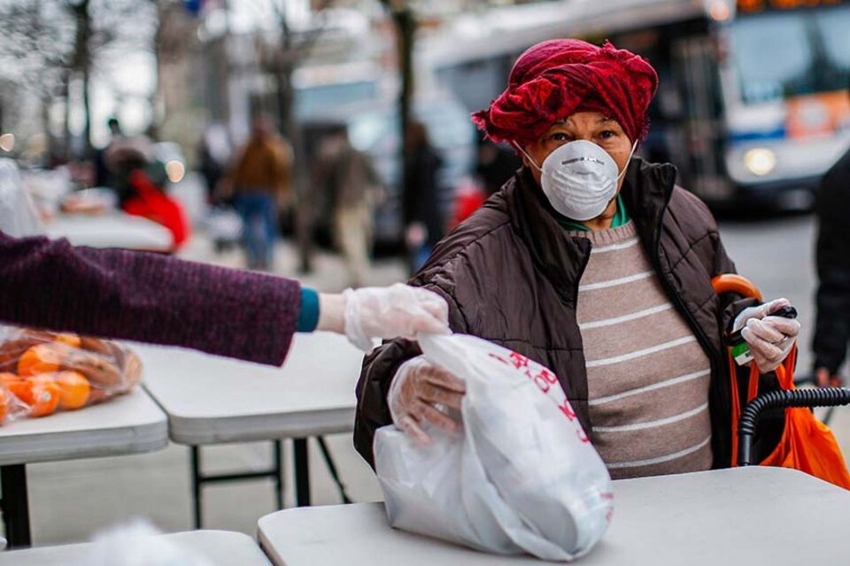 Una mujer desempleada recibe de manos de una voluntaria una bolsa de comida en Nueva York, el pasado 28 de marzo. (Fuente: AFP)