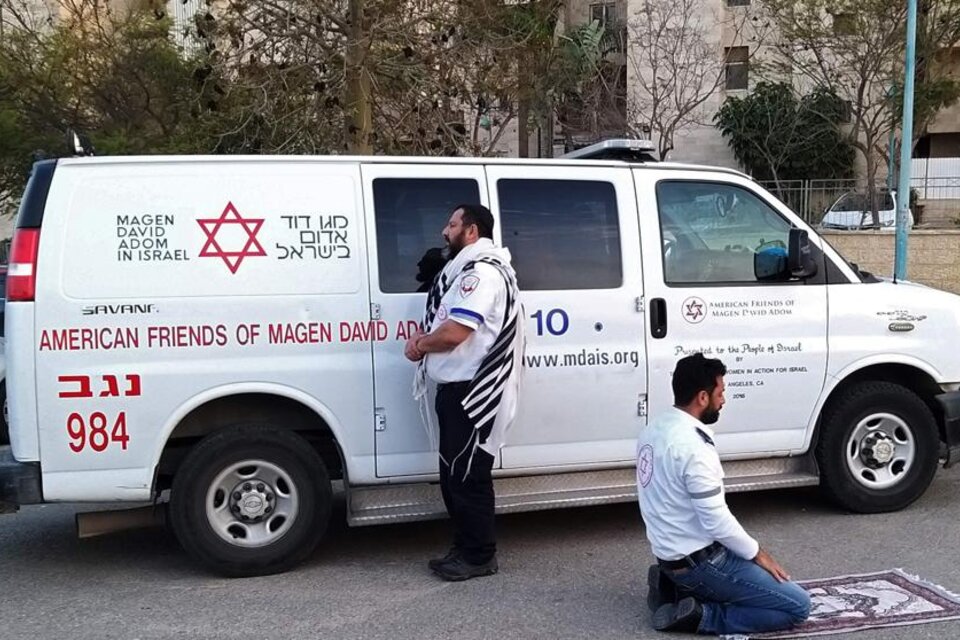 En Tel Aviv, un enfermero judío reza hacia Jerusalén, mientras su compañero musulmán reza hacia La Meca. (Fuente: AFP)