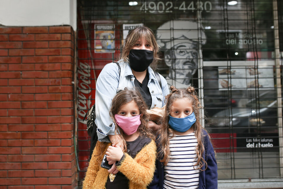 Una mujer y sus dos hijas mellizas de 6 años corriendo a hacer las compras en cuarentena.  (Fuente: Jose Nico)