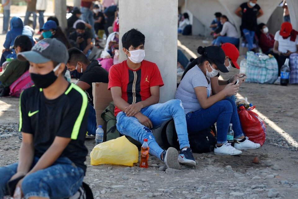 Un grupo de migrantes descansa bajo un puente de la ruta Panamericana Sur cerca de Lima.   (Fuente: EFE)