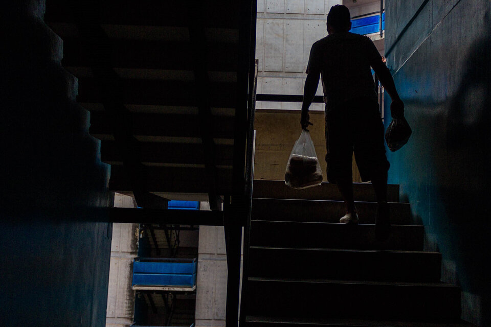 Un residente de Caracas regresa a su vivienda con una bolsa de compras en medio del apagón.  (Fuente: EFE)
