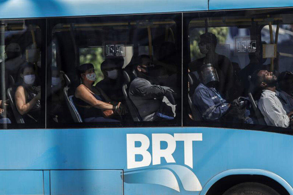 Pasajeros de un autobús en la zona norte de la ciudad de Río de Janeiro, el segundo estado de Brasil (después de San Paulo) más azotado por el coronavirus, tras haber contabilizado más de 17.000 casos y 1714 muertos hasta el domingo pasado.  (Fuente: Antonio Lacerda/EFE)