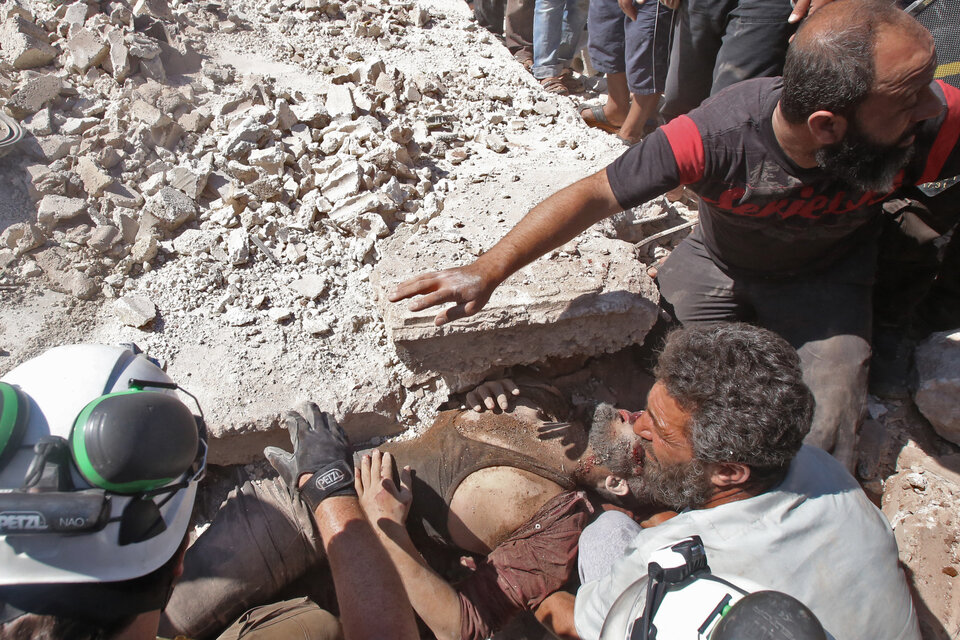 Rescatistas remueven a un herido de los escombros después de un bombardeo en Kafar roma, estado de Idlib.  (Fuente: AFP)