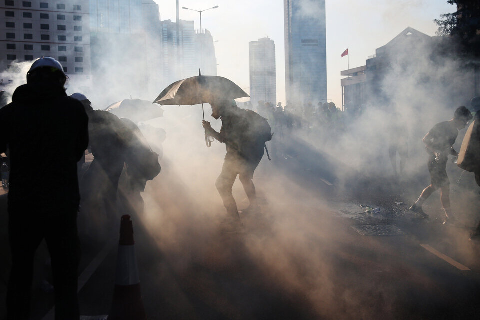 Manifestantes se apartan del gas lacrimógeno que usa la policía contra ellos.  (Fuente: EFE)