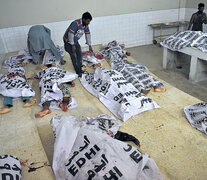 Voluntarios paquistaníes revisan los cadáveres de supuestos insurgentes abatidos ayer.