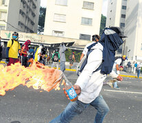 Un manifestante se prepara para lanzar una bomba Molotov en Caracas en un día de marchas a favor y en contra del gobierno. (Fuente: AFP) (Fuente: AFP) (Fuente: AFP)
