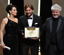 Juliette Binoche y Pedro Almodóvar entregan la Palma de Oro al director sueco Ruben Östlund. (Fuente: AFP) (Fuente: AFP) (Fuente: AFP)
