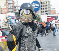 Un activista opositor usa una gomera durante una protesta contra el gobierno de Maduro.