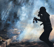 Un manifestante corre entre el gas lacrimógeno durante una marcha en Barquisimeto. (Fuente: EFE) (Fuente: EFE) (Fuente: EFE)