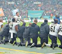Deportistas de la NFL se arrodillan en el campo de juego durante la entonación del himno.