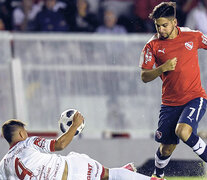 Martín Benítez intenta pasar la pelota por sobre el cuerpo de Kevin Mac Allister. (Fuente: Télam) (Fuente: Télam) (Fuente: Télam)