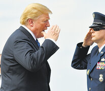 Trump saluda a un escolta en la base aérea Andrews antes de abordar el avión presidencial.
