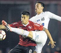 Meza disputa la pelota con el brasileño Pituca. El Rojo apenas empató 0-0 con Santos.