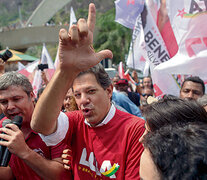 Rodeado por simpatizantes, Haddad hace la L de Lula con sus dedos durante su recorrida por Rocinha.