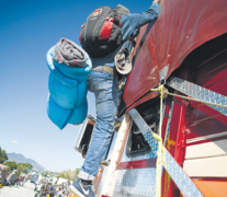 Un miembro de la caravana se sube a un camión en Jalisco.