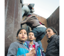 Niños de la caravana migrante trepan por una parte de la pared fronteriza. (Fuente: AFP) (Fuente: AFP) (Fuente: AFP)