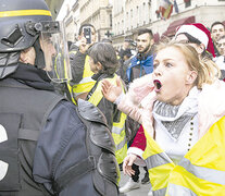 Una manifestante le gritaba a un policía durante la protesta de ayer en París.