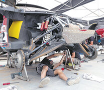 Los mecánicos trabajando en el Peugeot 3008 de Sebastien Loeb. Una rutina que se dio en cada campamento. (Fuente: EFE) (Fuente: EFE) (Fuente: EFE)