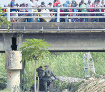 Policías vigilan el puente internacional Simón Bolívar que une Cúcuta con Táchira, mientras una marea humana cruza. (Fuente: AFP) (Fuente: AFP) (Fuente: AFP)