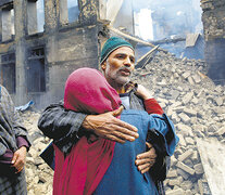 Abrazo frente a un edificio destruido por el fuego cruzado en la Cachemira india. (Fuente: EFE) (Fuente: EFE) (Fuente: EFE)