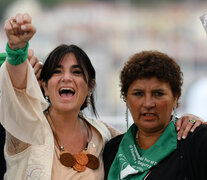 En Cannes, Norma Cuevas levanta la foto de la hija, Ana María Acevedo, junto a Cecilia Ousset.