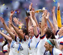 Megan Rapinoe con la Copa del Mundo y el resto del equipo celebrando el bicampeonato. (Fuente: AFP) (Fuente: AFP) (Fuente: AFP)