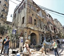 Un grupo de personas camina delante de edificios dañados por las explosiones en el barrio Achrafyeh Rmeil de Beirut. (Fuente: EFE) (Fuente: EFE) (Fuente: EFE)