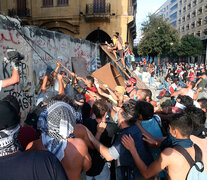 Manifestantes cargan contra una valla frente al Parlamento de Beirut. (Fuente: EFE) (Fuente: EFE) (Fuente: EFE)