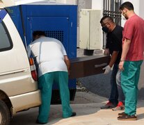 Empleados de la oficina forense cargan el cajón de una de las niñas en la morgue judicial. (Fuente: AFP) (Fuente: AFP) (Fuente: AFP)