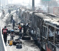 Funcionarios y peritos trabajan con los restos de buses de TransMilenio incinerados durante las protestas.  (Fuente: EFE) (Fuente: EFE) (Fuente: EFE)