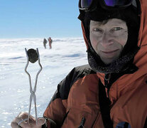 Oppenheimer feliz con una gema negra encontrada en el desierto blanco antártico.