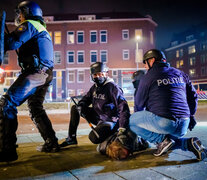 Policías detienen a un manifestante en Rotterdam por violar el toque de queda. (Fuente: AFP) (Fuente: AFP) (Fuente: AFP)