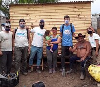 Vecinos y voluntarios de la ong Techo  junto a una vivienda construida.