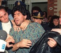 Maradona detendido, entre policías de civil, cámaras de televisión y vecinos que lo vitoreaban. (Fuente: AFP) (Fuente: AFP) (Fuente: AFP)
