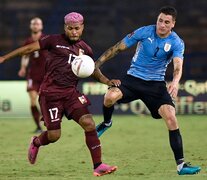 El uruguayo José María Giménez y el venezolano Josef Martínez disputan la pelota. (Fuente: AFP) (Fuente: AFP) (Fuente: AFP)