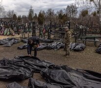 Dos policías observan los cadáveres trasladados al cementerio de Bucha.  (Fuente: EFE) (Fuente: EFE) (Fuente: EFE)