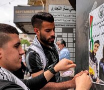 Los palestinos con carteles con los retratos del futbolista Thaer Yazouri y la periodista Shireen Abu Akleh (Fuente: AFP) (Fuente: AFP) (Fuente: AFP)