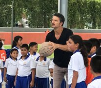 Ricardo Arjona, tira al aro tras una visita a una escuela.