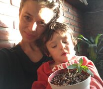 Una de las integrantes de Mamá Cultiva, junto a su hijo y los primeros esquejes de cannabis.