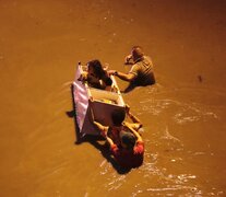 Los rescatistas usan una heladera como canoa para salvaguardar a unos niños. (Fuente: EFE) (Fuente: EFE) (Fuente: EFE)