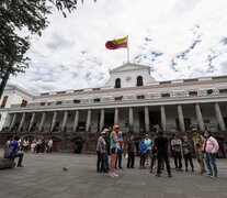 Ciudadanos ecuatorianos caminan a las afueras del Palacio de Gobierno este viernes en Quito
