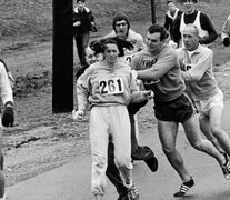 Kathy Switzer, empujada por otros corredores en la maratón de Boston