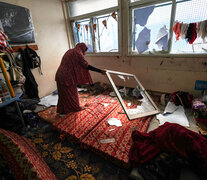 Una mujer revisa la habitación de una escuela que fue atacada por Israel en el centro de la Franja de Gaza. (Fuente: AFP) (Fuente: AFP) (Fuente: AFP)
