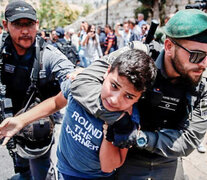 Un policía israelí toma del cuello de un manifestante palestino en Jerusalén. (Fuente: AFP) (Fuente: AFP) (Fuente: AFP)