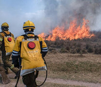 Los bomberos intentan apagar el fuego en expansión.