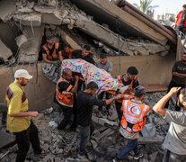 Resctistas extraen un cadaver de las ruinas de un edificio en Khan Yunis. (Fuente: AFP) (Fuente: AFP) (Fuente: AFP)